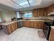A cozy kitchen with ample wood cabinets, stainless steel appliances, tile floor, and plenty of counter space at 105 Wood Duck Cir # D, Daytona Beach, FL 32119