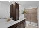Bathroom featuring dual sinks, vanity, an enclosed shower, and a decorative shelf at 11812 Metaphor Aly, Orlando, FL 32832