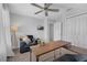 A relaxing bedroom featuring a chair, side table, ceiling fan and a closet with sliding doors at 11812 Metaphor Aly, Orlando, FL 32832