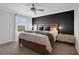 Modern bedroom with a striking black accent wall, wooden bed frame, and stylish nightstands at 11812 Metaphor Aly, Orlando, FL 32832