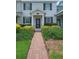 Inviting townhome featuring a well-manicured lawn and a charming brick pathway leading to the front door at 11812 Metaphor Aly, Orlando, FL 32832