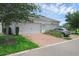 Two-car garage with brick-paved driveway and manicured landscaping at 11812 Metaphor Aly, Orlando, FL 32832