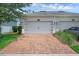 Two-car garage with brick-paved driveway and well-maintained landscaping at 11812 Metaphor Aly, Orlando, FL 32832