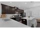 An elegant kitchen boasts dark cabinets, quartz countertops, stainless steel appliances and a stylish backsplash at 11812 Metaphor Aly, Orlando, FL 32832
