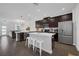 Modern kitchen featuring dark cabinets, stainless steel appliances, quartz countertops and island seating at 11812 Metaphor Aly, Orlando, FL 32832