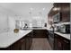 Modern kitchen featuring dark cabinets, stainless steel appliances, quartz countertops and island seating at 11812 Metaphor Aly, Orlando, FL 32832