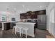 Spacious kitchen with stainless steel appliances, dark wood cabinets, quartz countertops and island with barstool seating at 11812 Metaphor Aly, Orlando, FL 32832