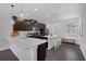 Modern kitchen featuring dark cabinets, quartz countertops, an island with seating, and stainless steel appliances at 11812 Metaphor Aly, Orlando, FL 32832