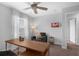Well-lit home office with neutral walls, a comfortable chair, a desk, and a ceiling fan at 11812 Metaphor Aly, Orlando, FL 32832