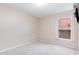 A spare bedroom with a window and beige carpet at 1199 Stoneham Dr, Groveland, FL 34736