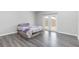 Bright bedroom featuring gray floors and sliding glass doors at 1199 Stoneham Dr, Groveland, FL 34736