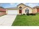 Charming single-Gathering home features an attached garage and well-manicured lawn at 1199 Stoneham Dr, Groveland, FL 34736