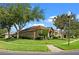 Well-manicured home exterior with lush landscaping, green lawn and mature trees at 12207 Shadowbrook Ln, Orlando, FL 32828
