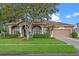Charming single-story home featuring a well-manicured lawn and inviting curb appeal with lush landscaping at 12207 Shadowbrook Ln, Orlando, FL 32828