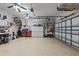 Spacious garage with epoxy floors, tool storage, lawn equipment, and overhead lighting at 12207 Shadowbrook Ln, Orlando, FL 32828
