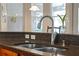 Functional kitchen featuring a double stainless steel sink, sleek faucet, and stylish countertop details at 12207 Shadowbrook Ln, Orlando, FL 32828