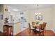 Bright dining area with a modern chandelier next to the breakfast bar and kitchen at 1300 Eastern Pecan Pl # 104, Winter Garden, FL 34787