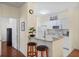 A bright kitchen with white cabinets and stainless steel appliances has an inviting breakfast bar with two stools at 1300 Eastern Pecan Pl # 104, Winter Garden, FL 34787