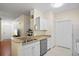 Cozy kitchen featuring white cabinets, granite countertops, stainless steel appliances, and tile flooring at 1300 Eastern Pecan Pl # 104, Winter Garden, FL 34787