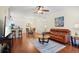 Bright living room featuring hardwood floors, a leather sofa, and a ceiling fan at 1300 Eastern Pecan Pl # 104, Winter Garden, FL 34787