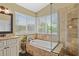 Bright bathroom with a soaking tub beneath a window and tiled glass shower at 1354 Dutch Elm Dr, Altamonte Springs, FL 32714