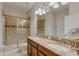 Bathroom with double sinks, granite countertops, vanity with cabinets, and glass enclosed shower at 1421 Wexford Way, Davenport, FL 33896