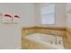 Inviting bathroom with soaking tub and decorative towel displays near a window at 1421 Wexford Way, Davenport, FL 33896
