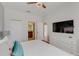 Bright bedroom with white walls, ceiling fan, and a large TV above a modern dresser at 1421 Wexford Way, Davenport, FL 33896