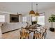 Open dining area with wood table, pendant lighting, and access to outdoor pool at 1421 Wexford Way, Davenport, FL 33896