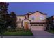 Charming two-story home with a brick driveway, a red front door, and well-maintained landscaping at 1421 Wexford Way, Davenport, FL 33896