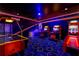 Recreation space showcasing arcade machines, air hockey, vibrant lighting, and custom carpeting, perfect for entertaining at 1421 Wexford Way, Davenport, FL 33896