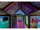 Unique hallway featuring custom artwork, thatched roofing and vibrant lighting, creating an immersive and playful atmosphere at 1421 Wexford Way, Davenport, FL 33896
