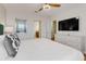 Bright main bedroom with white furniture, ceiling fan, and ensuite bathroom at 1421 Wexford Way, Davenport, FL 33896