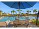 Relaxing community pool with a sun umbrella and outdoor seating with palm tree views at 1421 Wexford Way, Davenport, FL 33896