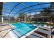 Inviting screened-in pool area with spa, lounge chairs, and lush green grass at 1421 Wexford Way, Davenport, FL 33896