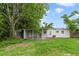 Backyard view of the home with a covered patio and spacious lawn at 147 Country Club Dr, Sanford, FL 32771