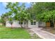 Charming one-story home with light-green exterior, mature trees, and a well-maintained front yard at 147 Country Club Dr, Sanford, FL 32771