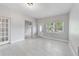 Open-concept living room with a white front door, lots of natural light, and light wood-look tile at 147 Country Club Dr, Sanford, FL 32771