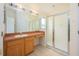 Bright bathroom featuring a single sink vanity, large mirror, and a glass-enclosed shower at 15309 Markham Dr, Clermont, FL 34714