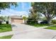 Charming single-Gathering home with a well-manicured lawn, palm tree, and a two car garage at 15309 Markham Dr, Clermont, FL 34714