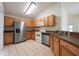 Functional kitchen featuring wood cabinets, stainless steel appliances, and tiled floors at 15309 Markham Dr, Clermont, FL 34714