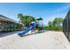 View of the playground area with blue slide, red climbing bars, and pea gravel ground cover at 15309 Markham Dr, Clermont, FL 34714