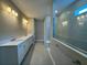 Bathroom featuring dual sinks, a vanity, and a glass-enclosed shower at 15569 Orchid Rose Ct, Winter Garden, FL 34787