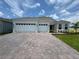 Charming single-Gathering home showcasing a three-car garage and a beautifully paved driveway at 15569 Orchid Rose Ct, Winter Garden, FL 34787