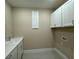 Bright laundry room with white cabinets, a white sink, and a grey tiled floor at 15569 Orchid Rose Ct, Winter Garden, FL 34787