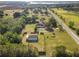Wide aerial view of property with separate outbuilding, mature trees, and road access, offering space and convenience at 16017 Johns Lake Rd, Clermont, FL 34711