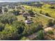 Scenic aerial view showcasing the property, outbuildings, lush greenery, and proximity to roads at 16017 Johns Lake Rd, Clermont, FL 34711