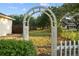Garden archway leading into a beautifully landscaped yard with greenery at 16017 Johns Lake Rd, Clermont, FL 34711