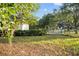 A fenced backyard with a variety of mature trees on a sunny day creates a peaceful atmosphere at 16017 Johns Lake Rd, Clermont, FL 34711