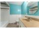 Bathroom featuring tiled tub with white wainscoting and sink with granite countertop at 16017 Johns Lake Rd, Clermont, FL 34711